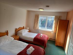 a hotel room with two beds and a window at Snowdonia Mountain Lodge in Bethesda