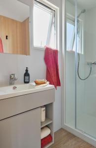 een badkamer met een wastafel en een douche bij Camping La Forêt Stella-Plage in Stella-Plage