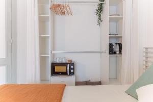 Habitación con cama y microondas en un estante en Charmante suite aux Chartrons, en Burdeos