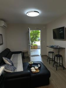 Apartment Punta skala Villa Valentina في بيتريتشاني: غرفة معيشة مع أريكة سوداء وطاولة