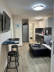 uma sala de estar com um sofá preto e uma cozinha em Apartment Punta skala Villa Valentina em Petrcane