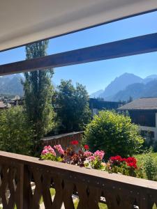 a balcony with flowers and a view of mountains at Ciasa Valiares in San Vigilio Di Marebbe