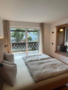 a bedroom with a bed and a large window at Ciasa Valiares in San Vigilio Di Marebbe