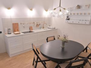 una cocina con mesa negra, sillas y fregadero en Mediterranea Home Napoli, en Nápoles 27 fotos más