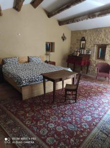 um quarto com uma cama e uma mesa num quarto em La Crozette - Mas Provençal em Saint-Restitut