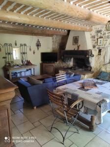 uma sala de estar com um sofá azul e uma mesa em La Crozette - Mas Provençal em Saint-Restitut