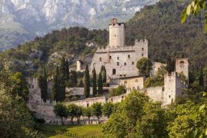 a castle on a hill with mountains in the background at Appartamento CS in Sabbionara