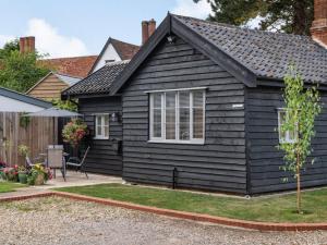 une maison noire avec un toit en pente dans l'établissement 1 Bed in Finningham 85401, à Finningham