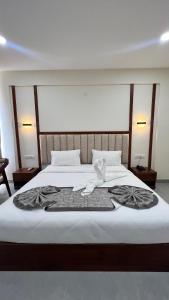 a bedroom with a bed with a towel on it at Vrishi Inn in Bangalore