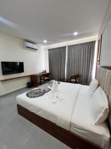 a hotel room with a bed and a television at Vrishi Inn in Bangalore