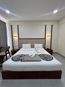 a hotel room with a bed with towels on it at Vrishi Inn in Bangalore