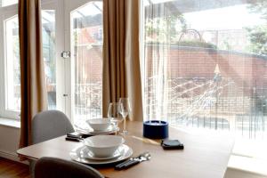 a table with two plates and glasses and a window at Cosy 1 Bed Apt near Manchester City Centre in Manchester