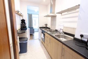 a kitchen with a sink and a counter top at Cosy 1 Bed Apt near Manchester City Centre in Manchester