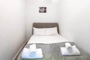 a small bedroom with a bed with towels on it at Cosy 1 Bed Apt near Manchester City Centre in Manchester