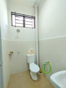 a bathroom with a toilet and a sink at Indah Damai Homestay in Kepala Batas
