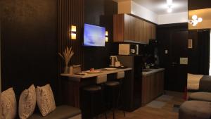 een keuken met een bar met een tv aan de muur bij Studio Apartment-Avida Sucat Tower 9 in Manilla