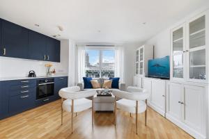 a kitchen with blue cabinets and a table and chairs at Stylish Central London Bolthole in London