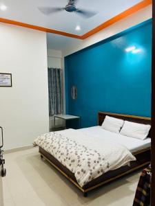 a bedroom with a bed with a blue wall at Prem Bhawan Guest House in Khātu