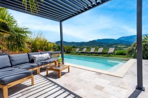 a patio with a couch and a swimming pool at Gite Les Aiguillans in Mérindol-les-Oliviers