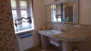 ein Bad mit einem Waschbecken und einem Spiegel in der Unterkunft Dom Gościnny Brama Sudecka in Lubawka