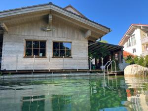 une maison avec une piscine en face d'un bâtiment dans l'établissement Chalet Bad Tölz, à Bad Tölz