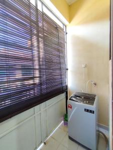 a small refrigerator in a room with a window at Indah Damai Homestay in Kepala Batas