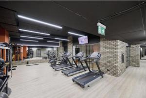 une salle de sport avec une rangée de tapis de course et de machines dans l'établissement LuxuryCity Apartment with Terrace, à Wrocław