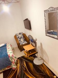 a bedroom with a bed and a mirror and a chair at WINZMAR LODGE in Lusaka