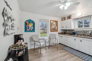 a kitchen with white cabinets and a table and chairs at White House Bungalow in Bay City