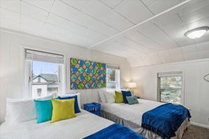 dwa łóżka w pokoju z dwoma oknami w obiekcie White House Bungalow w mieście Bay City