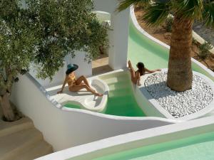 Zwei Mädchen rutschen auf einer Wasserrutsche in einem Ferienresort in der Unterkunft Aloni Hotel & Suites in Piso Livadi