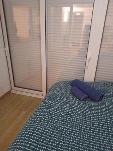 a bed with a blue pillow on top of it at Hendaye Beach Studio, front de mer avec parking privé in Hendaye