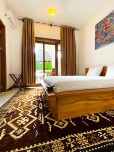a bedroom with a bed and a large window at Oxygen Paje Hotel in Paje