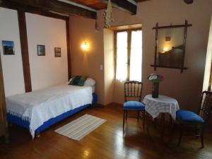 a bedroom with a bed and a table and chairs at Le Figuier in Anglars