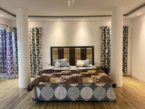 een slaapkamer met een groot bed met kussens en gordijnen bij Move Inn- The suite in Dibrugarh