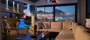 Sunsea Wellness Resort في آغيوس ستيفانوس: غرفة معيشة مع أريكة وطاولة