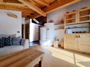 un soggiorno con divano e tavolo di Casa Panoràma in the heart of the Dolomites, Moena a Moena