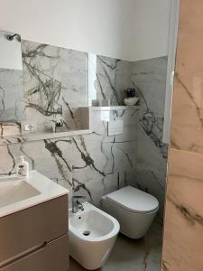 a bathroom with a white toilet and a sink at La Corte del Moro in Pachino
