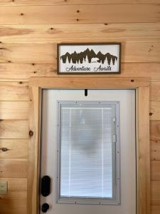ein Schild über einem Fenster über einer Tür in der Unterkunft Cozy Bear Mountain Tiny House in Travelers Rest