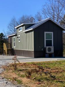 ein schwarz-weißes Haus mit einer Veranda in der Unterkunft Cozy Bear Mountain Tiny House in Travelers Rest