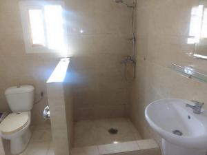 łazienka z toaletą i umywalką w obiekcie RT GUEST HOUSE w Port-Gentil