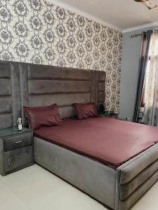 a bedroom with a large bed with a red mattress at Urban Oasis in Zirakpur