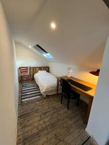Cette chambre comprend un lit et un bureau. dans l'établissement Maison bord de Marne pour 10 personnes avec jacuzzi, à Châlons-en-Champagne