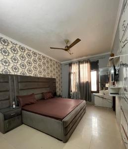 a bedroom with a bed and a ceiling fan at Urban Oasis in Zirakpur