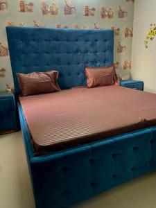 a bed with a blue headboard in a room at Urban Oasis in Zirakpur