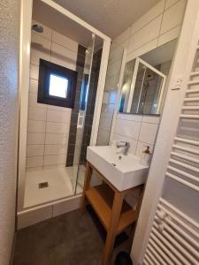 uma casa de banho com um lavatório e um chuveiro em Le Cantou - cocon chaleureux em Font Romeu Odeillo Via