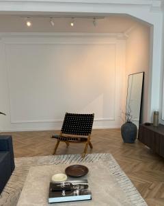 uma sala de estar com uma cadeira e uma parede branca em Kukučínova apartment em Bratislava