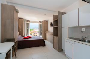 Habitación pequeña con cama y cocina en Hôtel et Résidence Ta Kladia - Omigna, en Cargèse