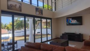 a living room with a couch and a flat screen tv at The Palace in Izinga Estate Umhlanga in Durban