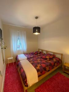 Schlafzimmer mit einem Bett und einem roten Teppich in der Unterkunft River Place in Porto